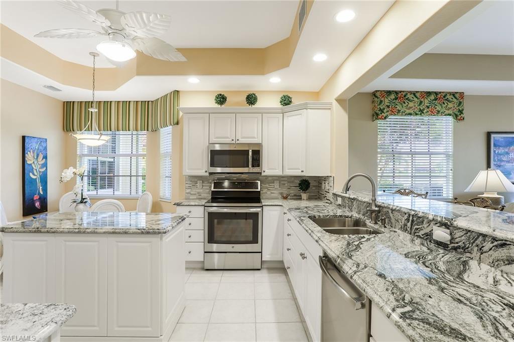 8609 Champions Point, Unit 201 Naples, FL 34113 - Photo 10 of 25 a kitchen with granite countertop a sink stainless steel appliances and cabinets