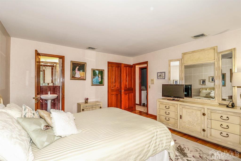 164 Devon Road Colonia, NJ 07067 - Photo 27 of 42 a bedroom with a bed and a flat screen tv