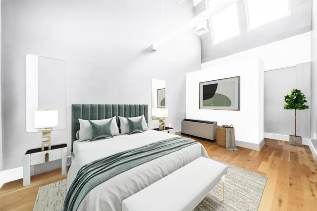 a bedroom with a large bed a flat tv screen and a potted plant