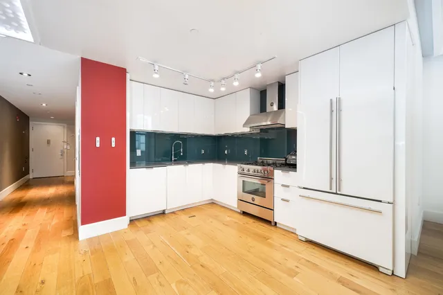 a view of a kitchen with a refrigerator and a sink