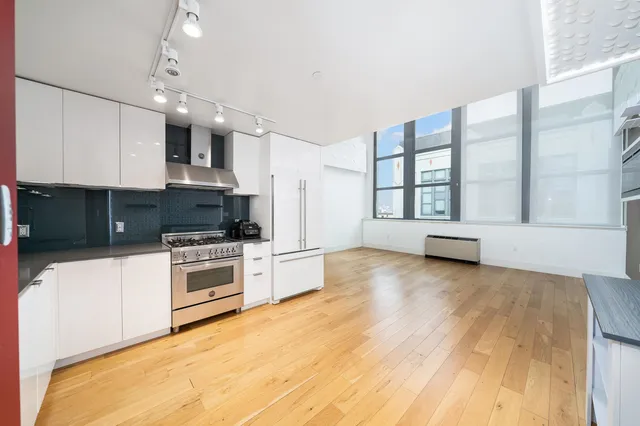 a large kitchen with stainless steel appliances granite countertop a stove a sink and a microwave