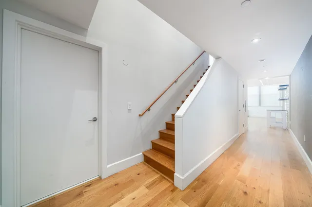 a view of a hallway with wooden floor and staircase