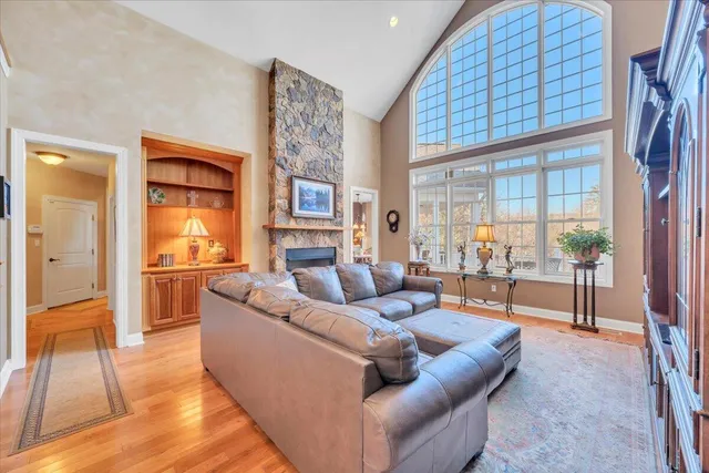 a spacious bedroom with a large bed a chandelier and windows