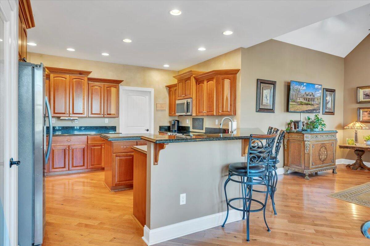 5565 Carons View Lane Roanoke, VA 24014 - Photo 27 of 118 a kitchen with stainless steel appliances granite countertop a refrigerator a sink a stove a dining table and chairs with wooden floor