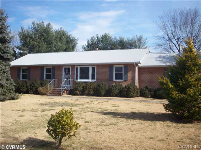 a front view of a house with a yard covered in snow