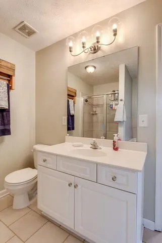 a bathroom with a sink a toilet a mirror and vanity