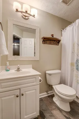 a bathroom with a toilet a sink and a mirror