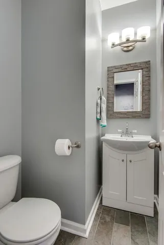 a bathroom with a toilet a sink and mirror