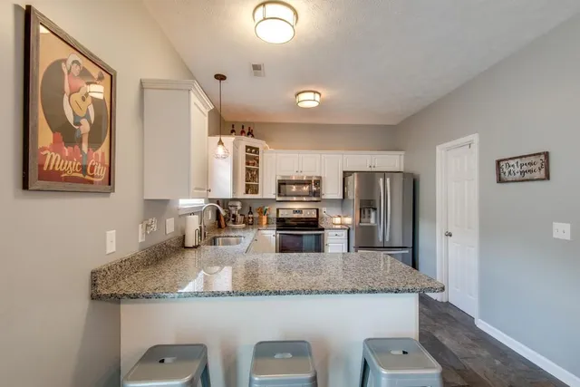 a kitchen with granite countertop stainless steel appliances a refrigerator and a counter space