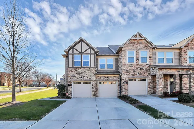 a front view of a house with a yard and fountain in middle