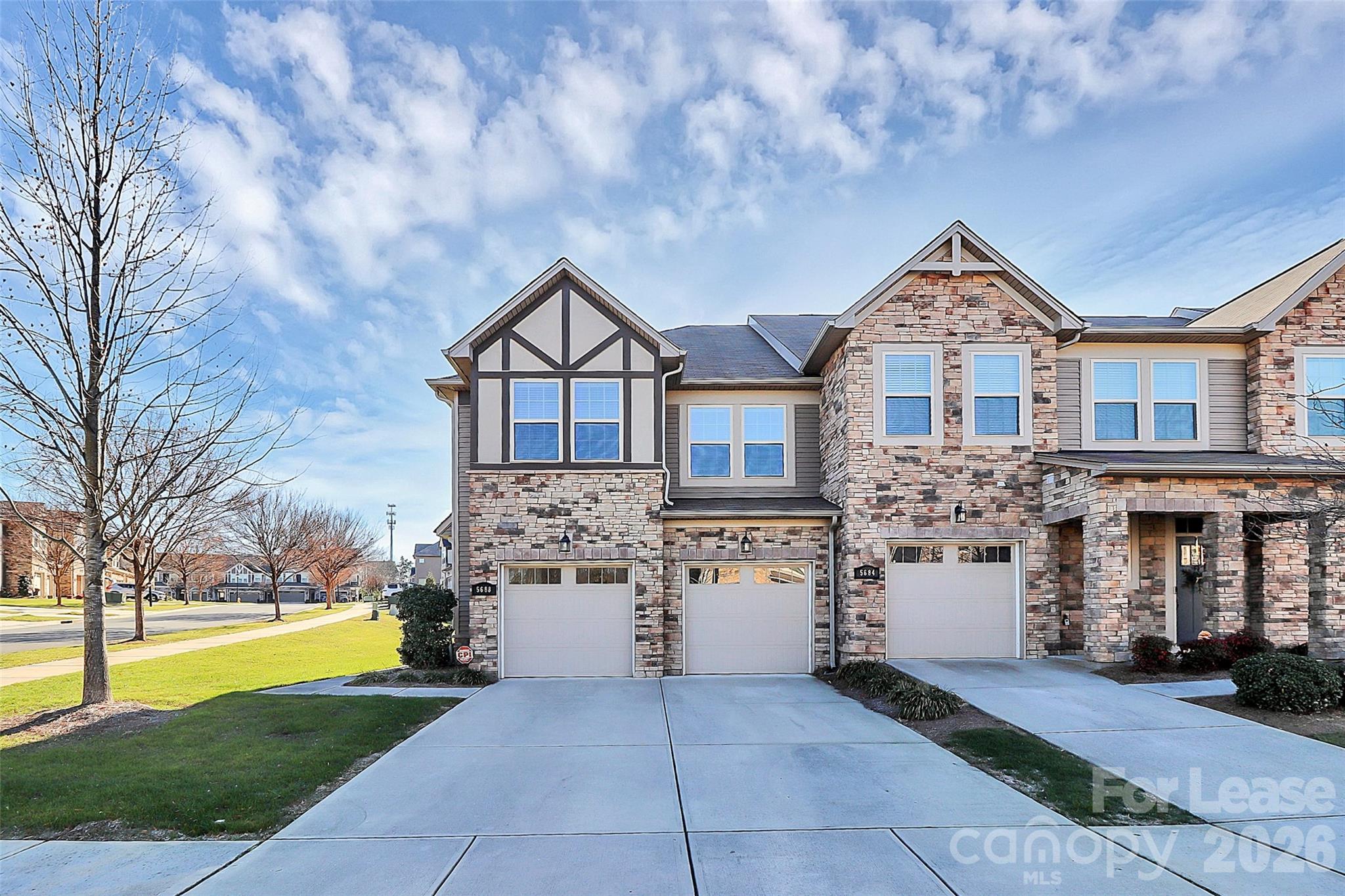 a front view of a house with a yard and fountain in middle