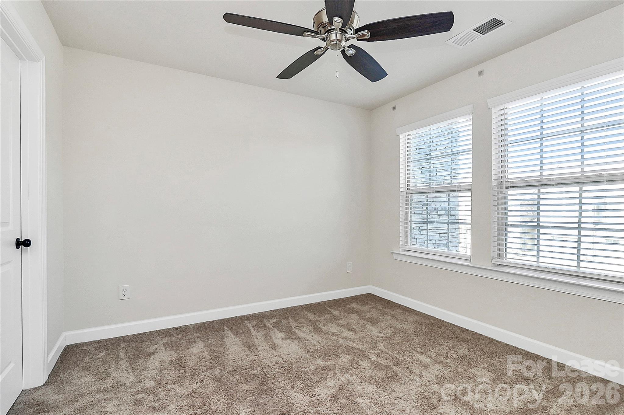 5688 Garrow Glen Road Charlotte, NC 28278 - Photo 13 of 17 an empty room with a window and a fan