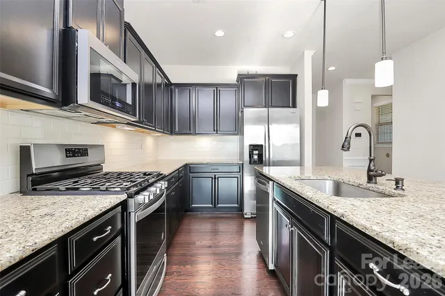 a kitchen with granite countertop stainless steel appliances and wooden cabinets