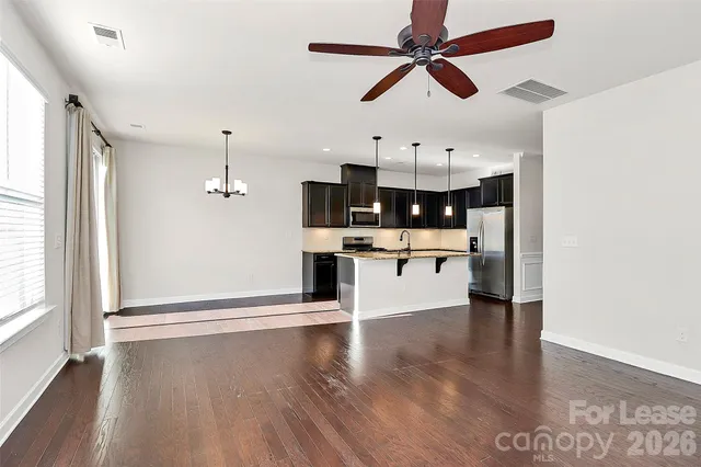 a view of counter top space with stainless steel appliances wooden floor and a window