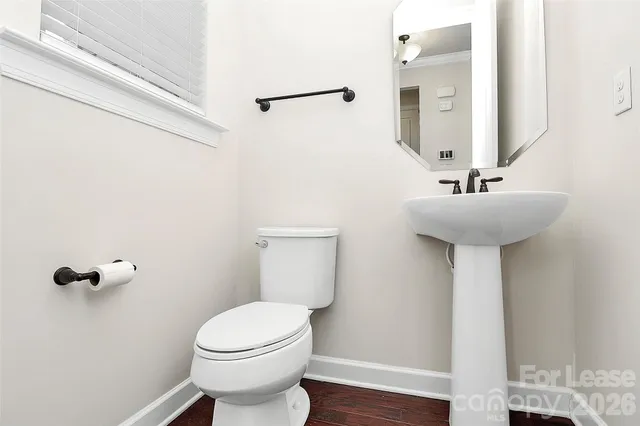 a bathroom with a sink toilet and a mirror