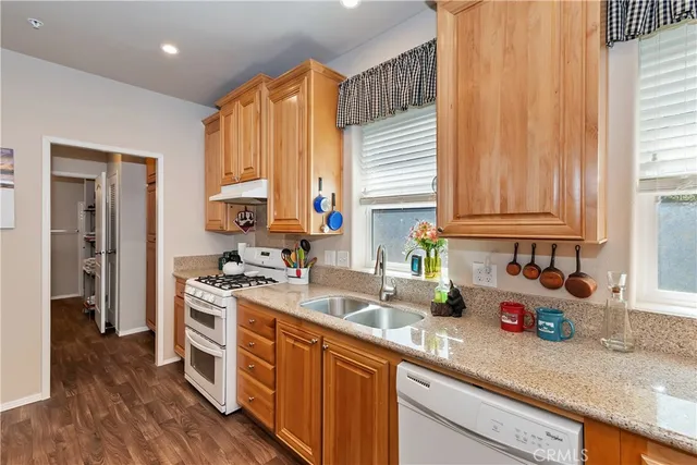 a kitchen with stainless steel appliances granite countertop wooden cabinets a sink and a window