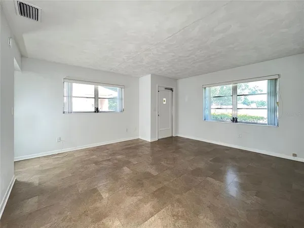 an empty room with windows and closet