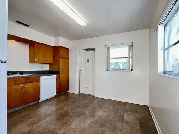 a kitchen with granite countertop a stove top oven sink and cabinets