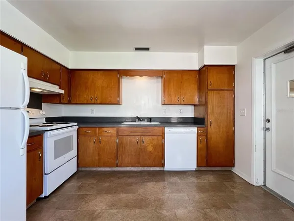 a kitchen with stainless steel appliances granite countertop a stove a sink and a refrigerator