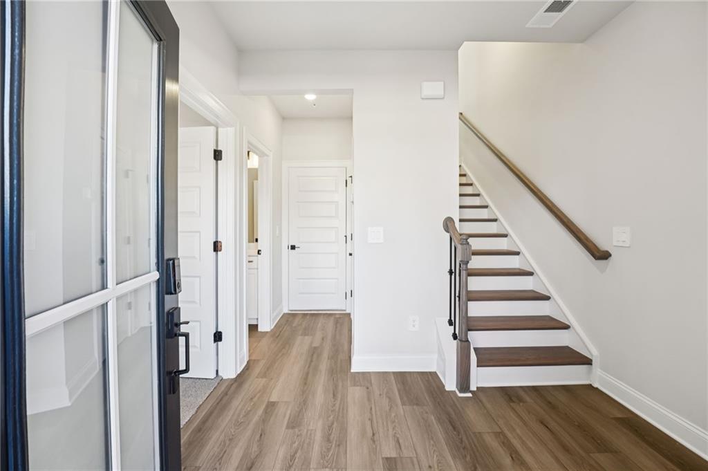 6450 Pinin Place Cumming, GA 30041 - Photo 6 of 53 a view of a hallway with wooden floor and entryway