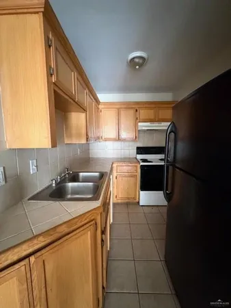 a kitchen with a sink appliances and cabinets