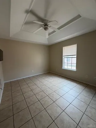 an empty room with windows and ceiling fan