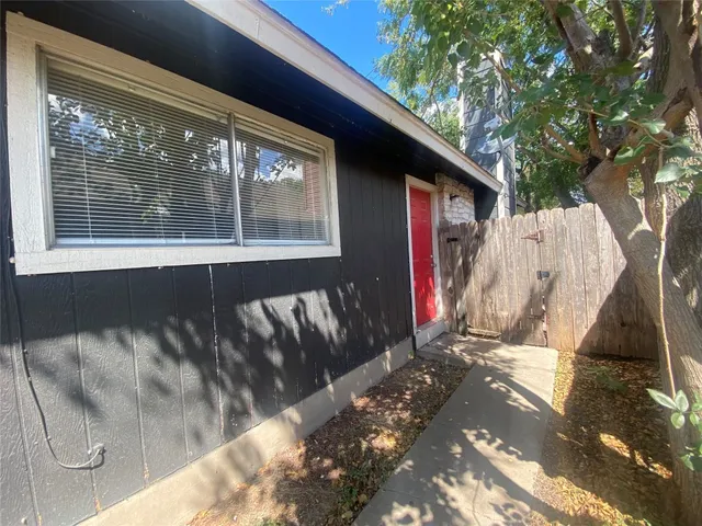 a view of backyard with wooden fence and a large tree