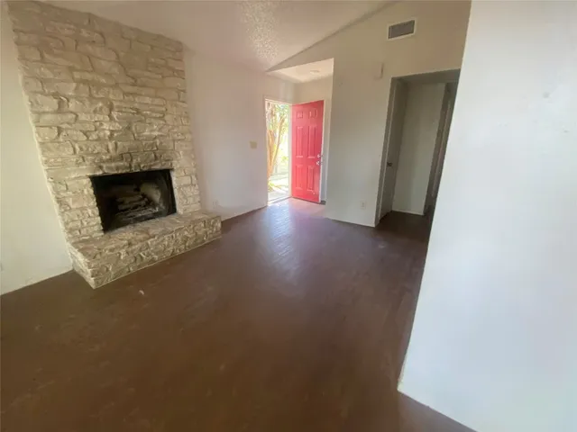 a view of a livingroom with wooden floor and a fireplace