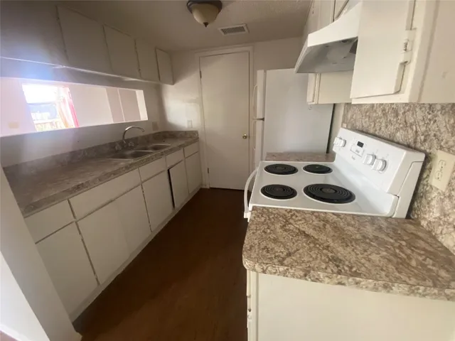 a kitchen with a stove a sink and a refrigerator