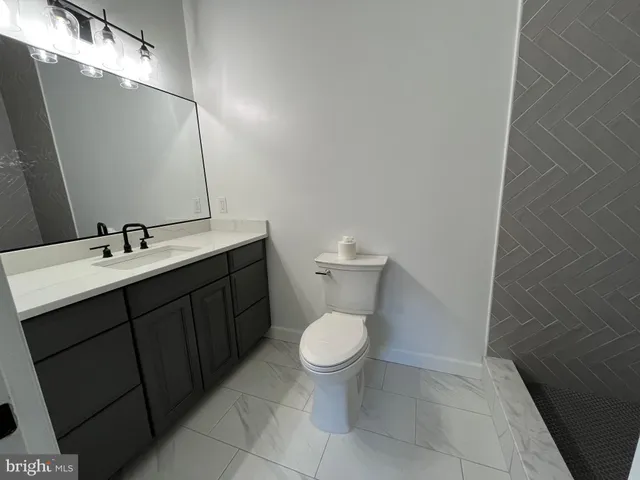 a bathroom with a sink toilet and a mirror