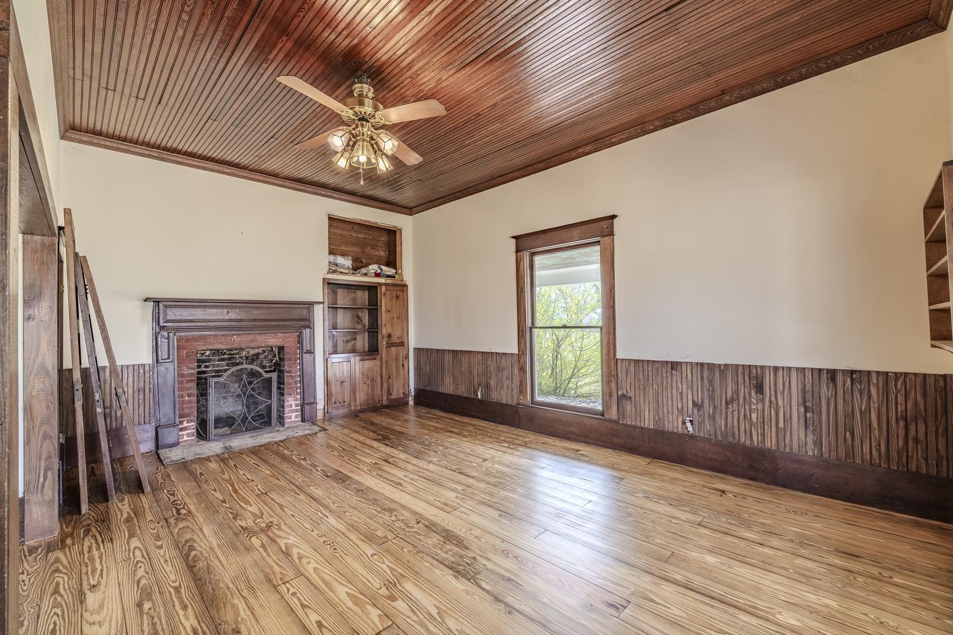 2055 Kendrick Road Michie, TN 38357 - Photo 20 of 37 a view of an empty room with wooden floor fireplace and a window