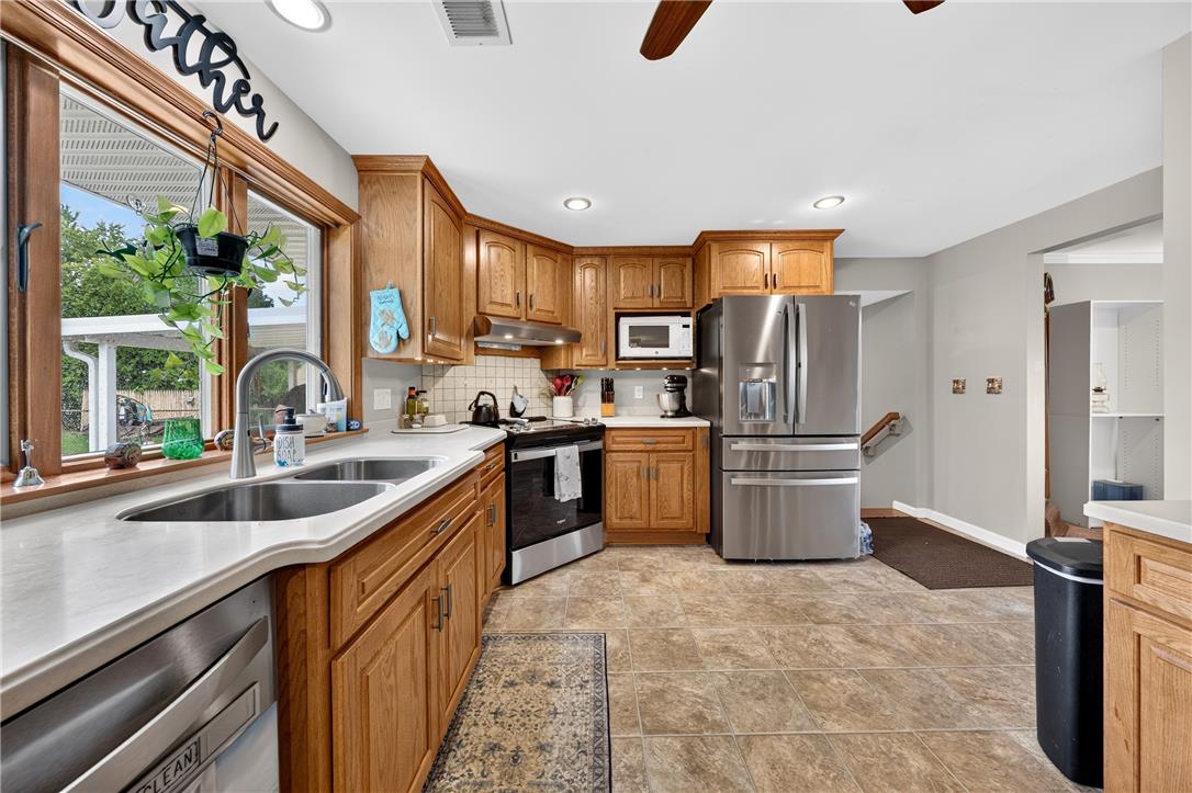 1307 Klinerd Road Pennsburg, PA 18073 - Photo 11 of 53 Rich wood cabinetry and stone-look tile flooring anchor this functional culinary workspace.