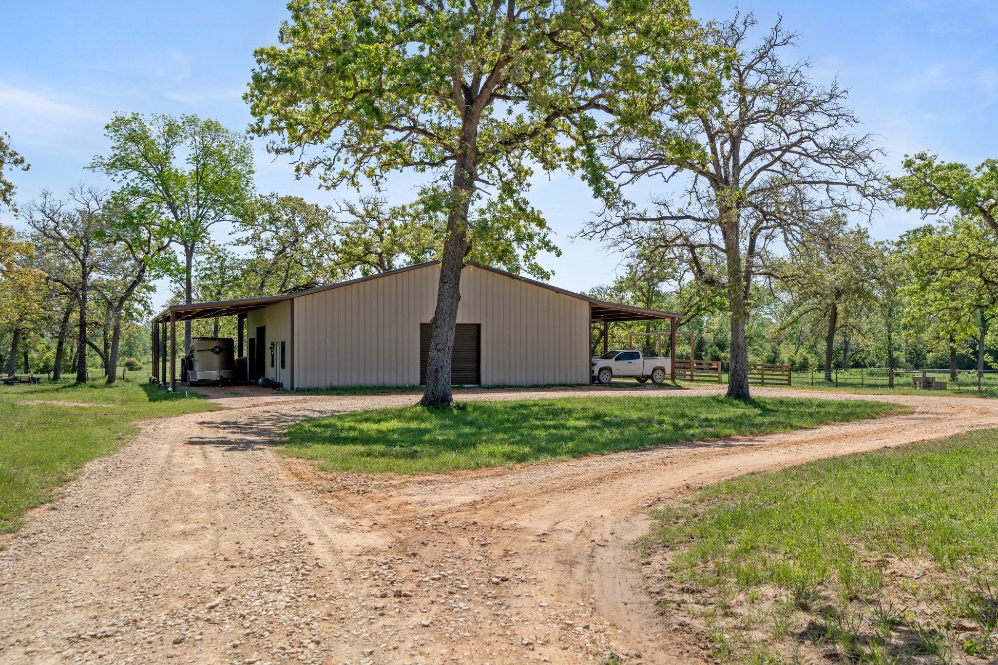 4052 Kuykendall Road Bellville, TX 77418 - Photo 28 of 40 The property features a convenient metal barn with tack rooms and horse stalls just steps from your home, perfect for equestrian enthusiasts.