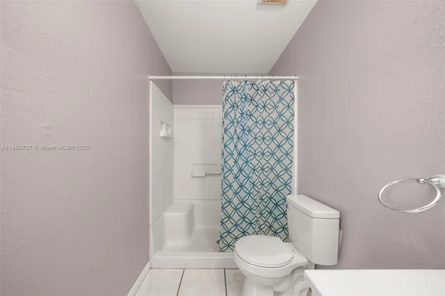 a white toilet sitting next to a shower curtain