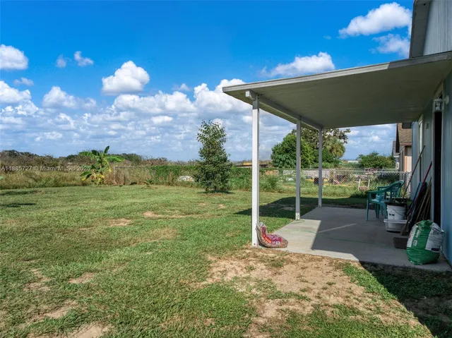 a view of a porch with a table and chairs under an umbrella