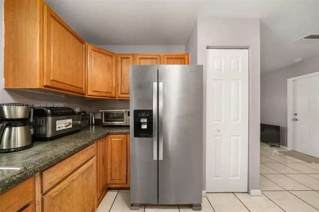 a kitchen with stainless steel appliances granite countertop a refrigerator a stove and a sink with cabinets