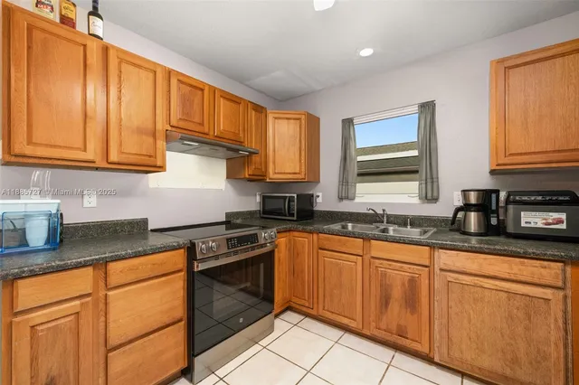 a kitchen with stainless steel appliances granite countertop a sink stove and cabinets