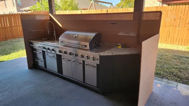 a kitchen with kitchen island granite countertop stainless steel appliances a sink stove refrigerator and cabinets