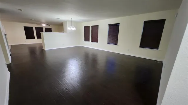 a view of a big room with wooden floor and windows