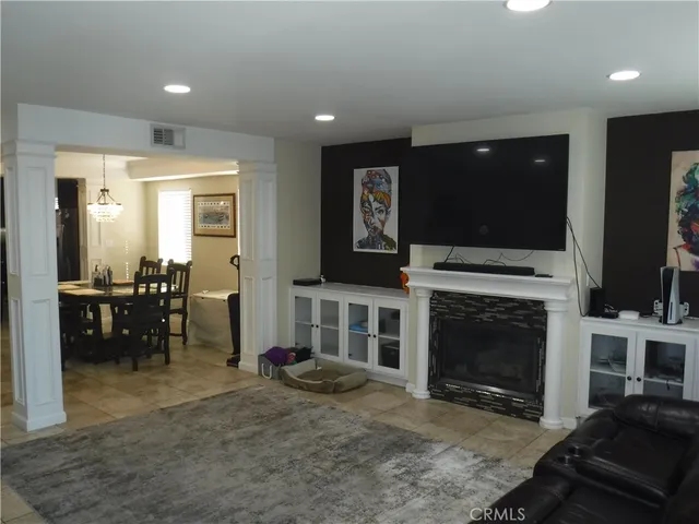 a living room with furniture a flat screen tv and a fireplace