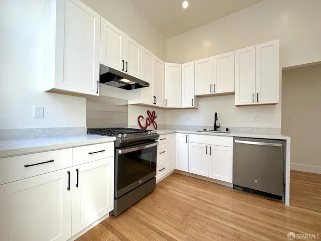 a kitchen with granite countertop white cabinets and white appliances