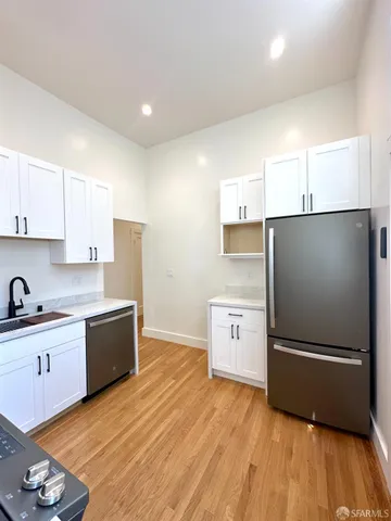 a kitchen with a refrigerator and a stove top oven