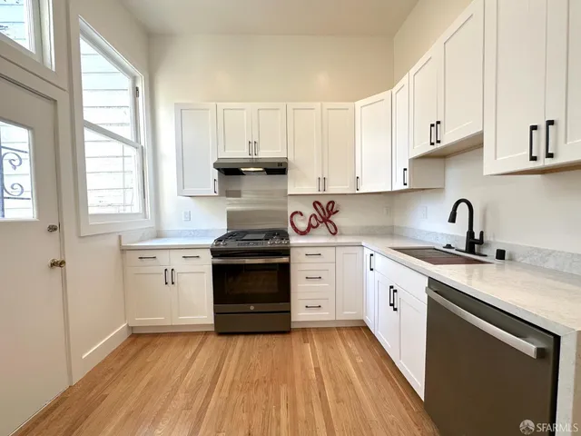 a kitchen with granite countertop a stove sink and cabinets
