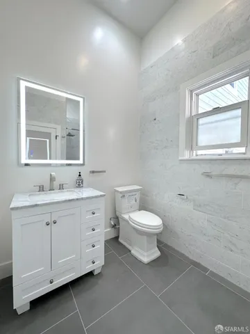 a bathroom with a toilet sink and mirror
