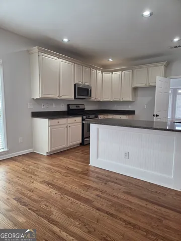 a kitchen with stainless steel appliances granite countertop a stove a sink and a microwave