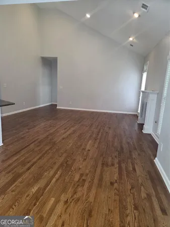 an empty room with wooden floor and entrance