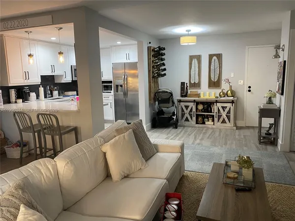 a living room with furniture wooden floor and a large window