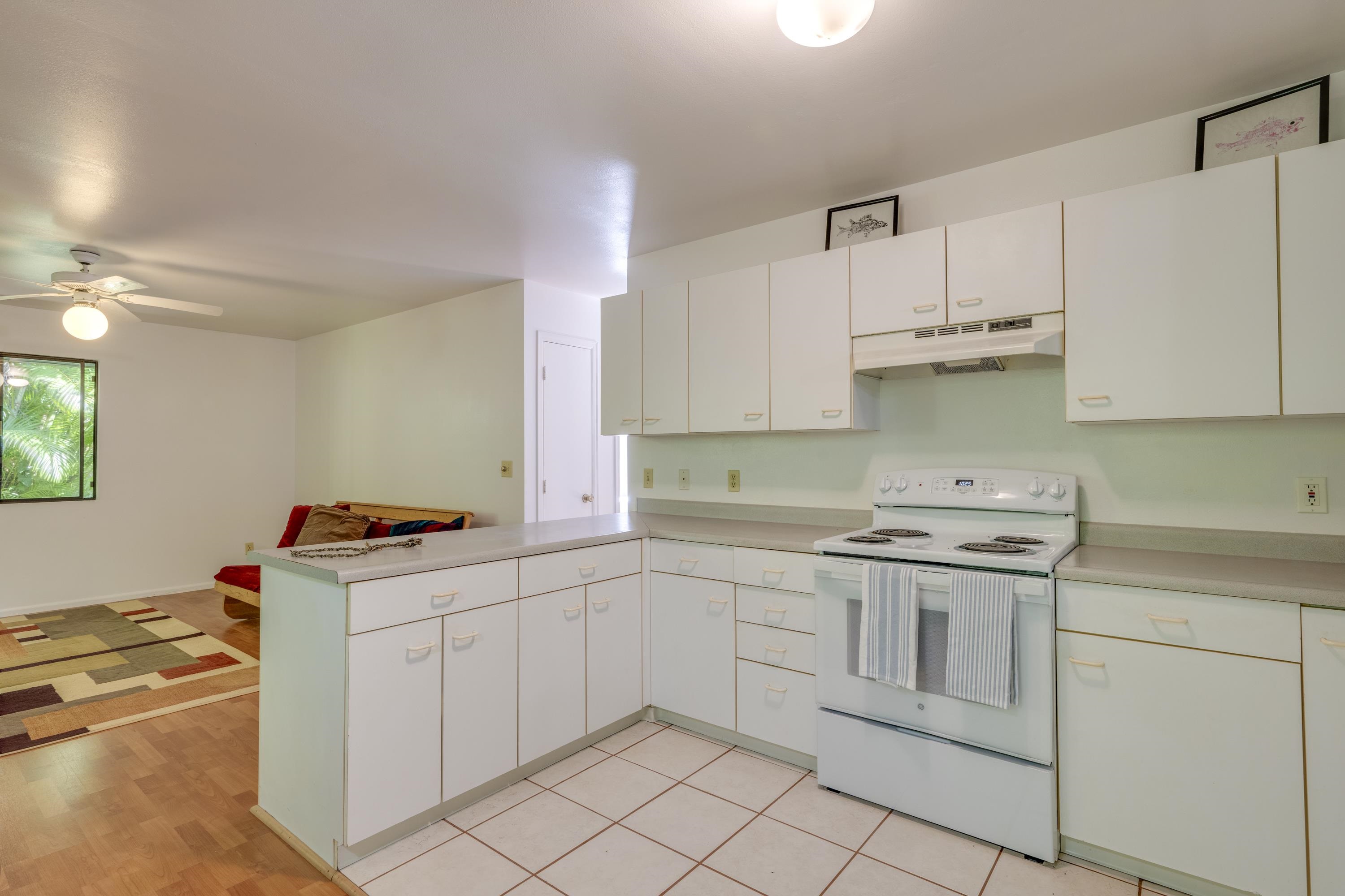 1002 Kauhikoa Road, Unit 2 Haiku, HI 96708 - Photo 11 of 24 a kitchen with cabinets appliances and a sink