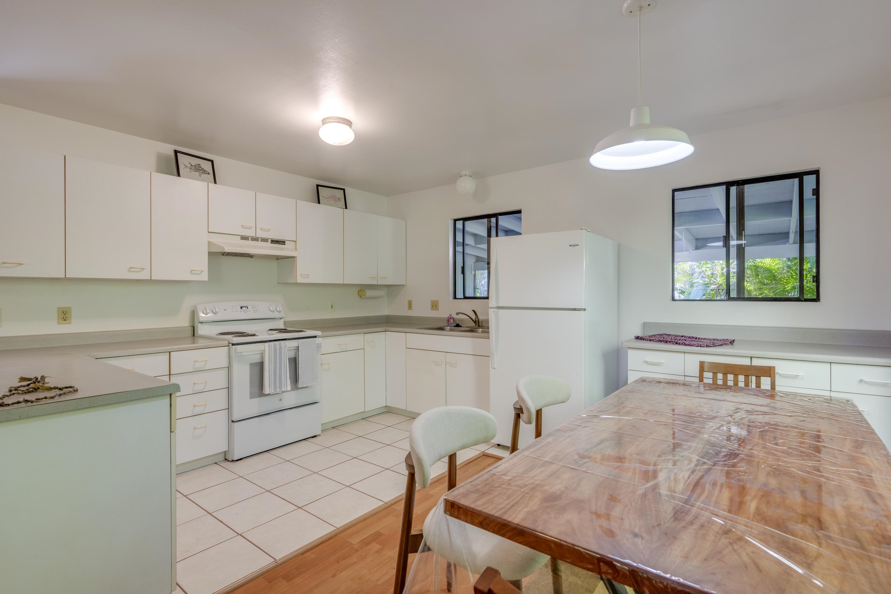 1002 Kauhikoa Road, Unit 2 Haiku, HI 96708 - Photo 12 of 24 a kitchen with white cabinets and white appliances