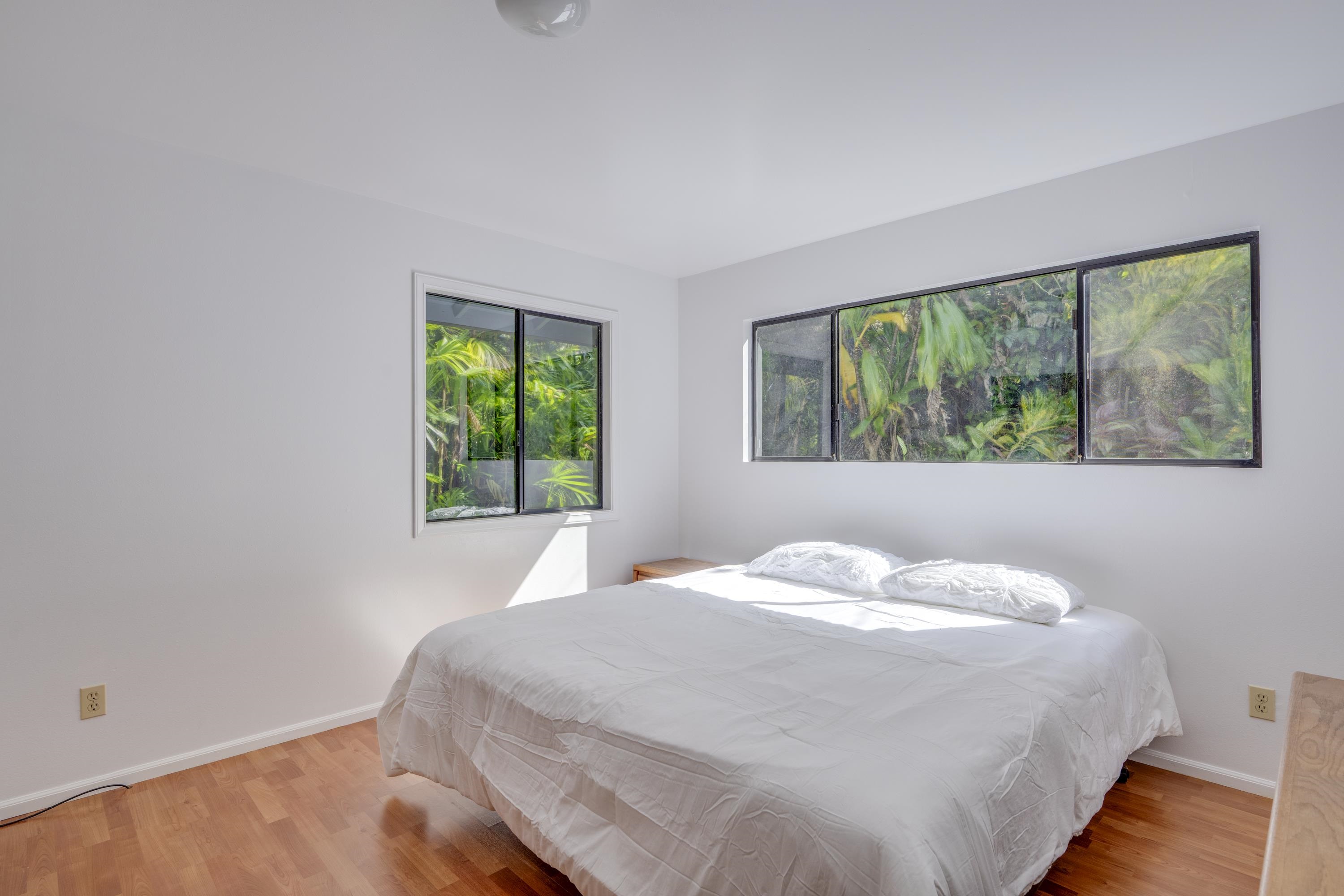 1002 Kauhikoa Road, Unit 2 Haiku, HI 96708 - Photo 17 of 24 a bedroom with a bed and a window